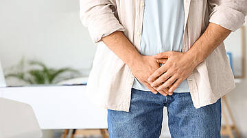 Urologenzentrum Wien - Prostatasteine: Abbildung eines Mannes mit Beschwerden im Beckenbereich.
