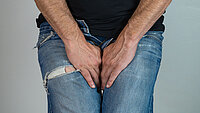 Urologenzentrum Wien - Peniskarzinom, Person zeigt Anzeichen von Unbehagen.