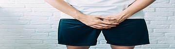 Balanitis - Symptome von Beschwerden im Genitalbereich. Urologenzentrum Wien - Balanitis: Mann zeigt Beschwerden im Genitalbereich.