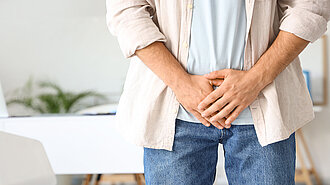 Urologenzentrum Wien - Prostatasteine: Abbildung eines Mannes mit Beschwerden im Beckenbereich.